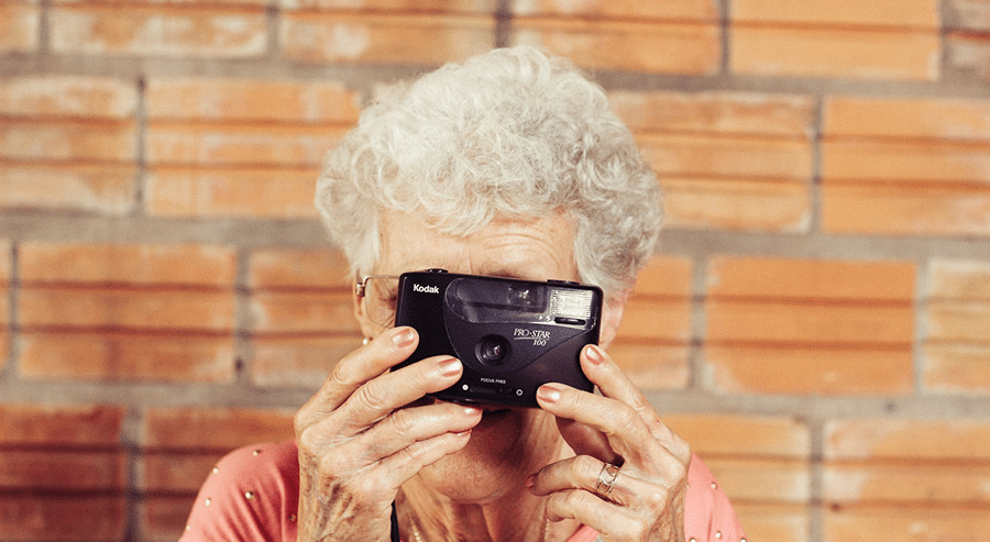 Granny taking picture using an old film camera