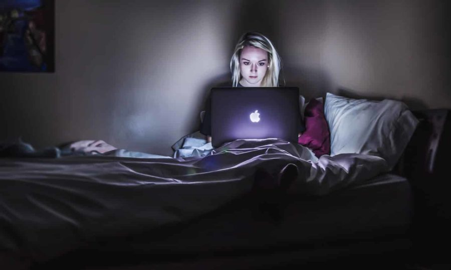 Woman working with her Laptop on her bed