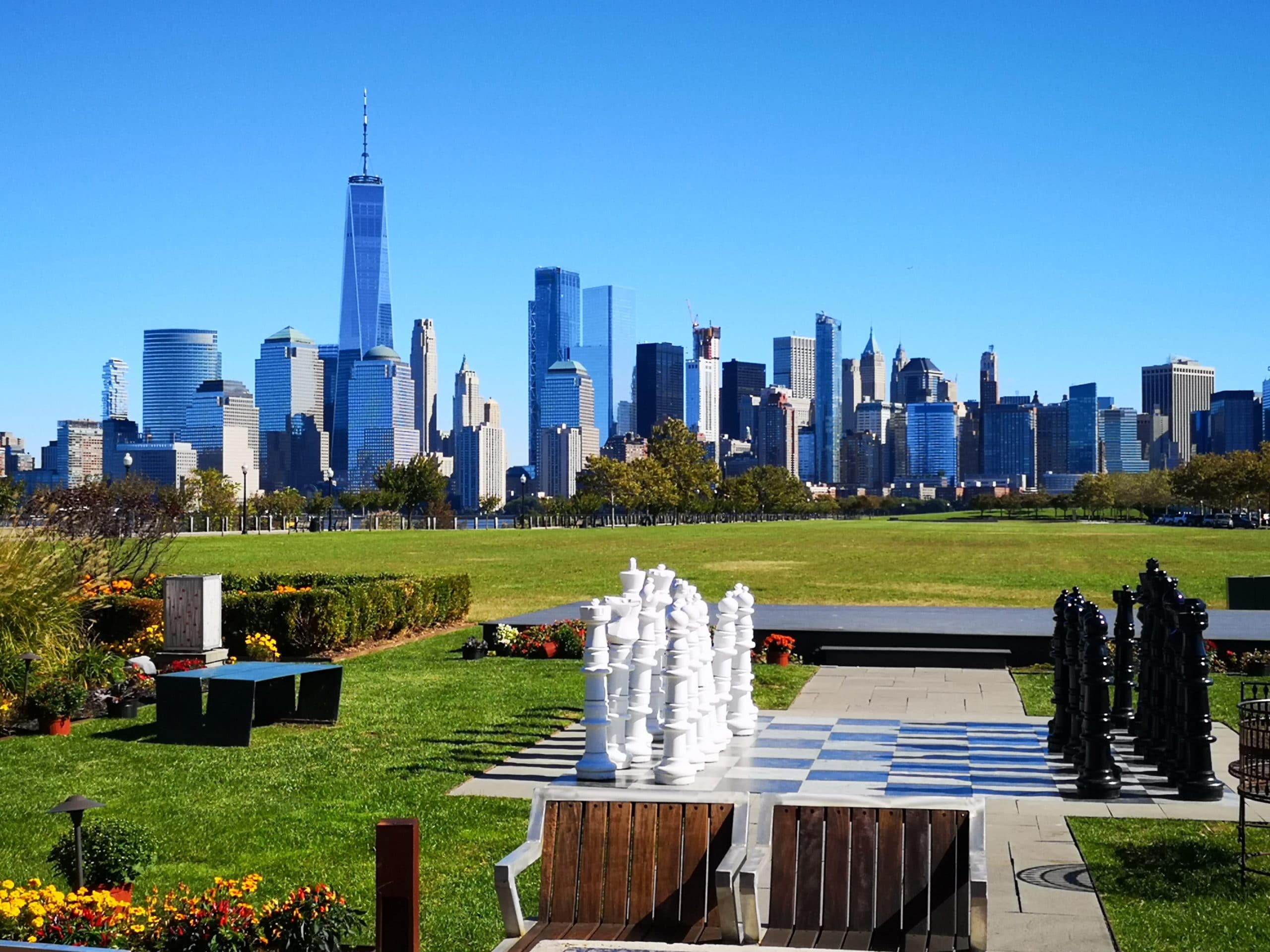 Image of New Jersey skyline with park and large chess board in the foreground