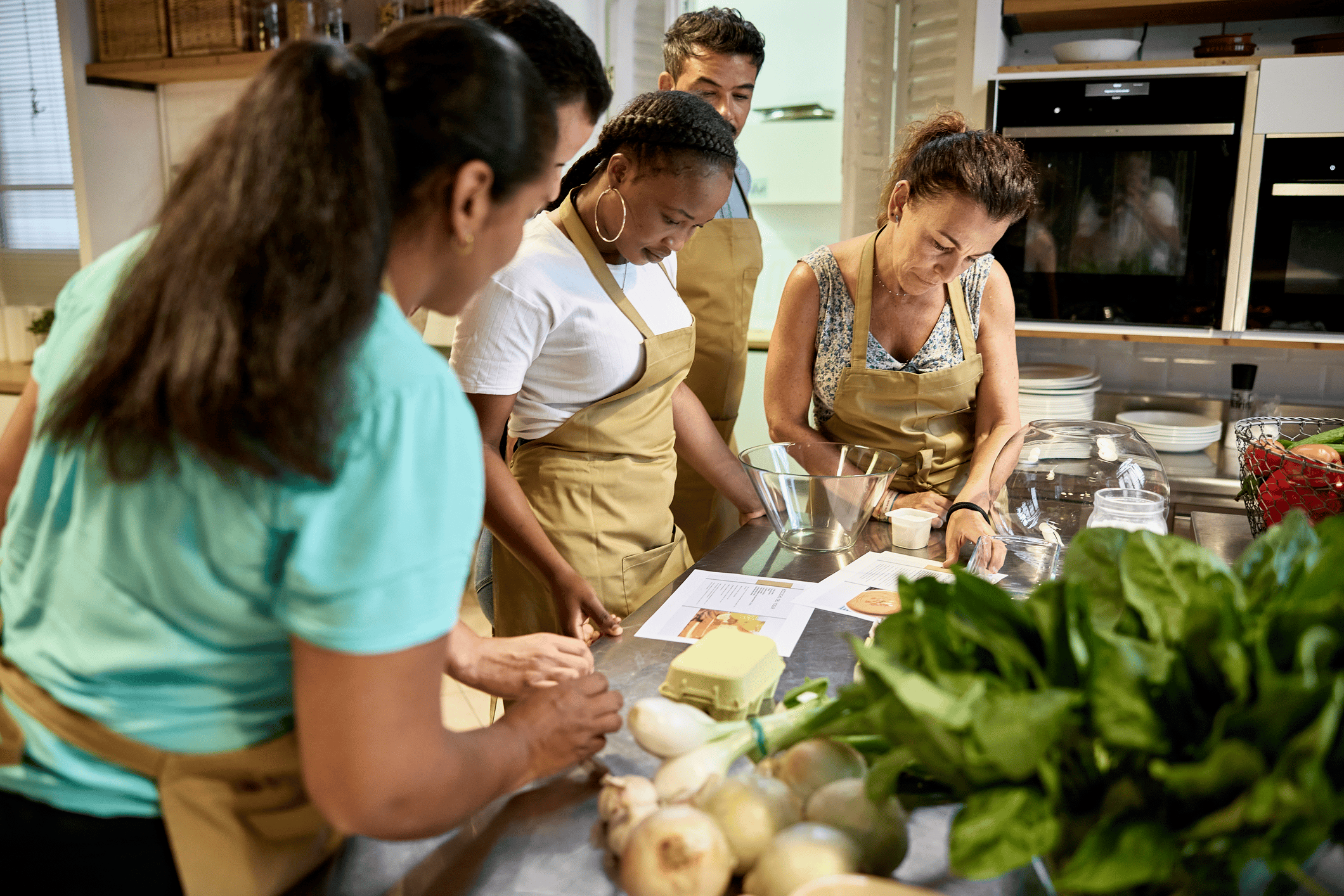 A cooking class with several people reading a recipe