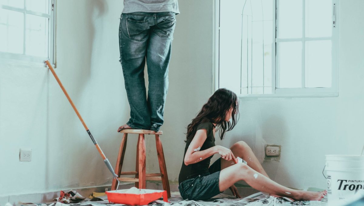 A couple painting an interior wall