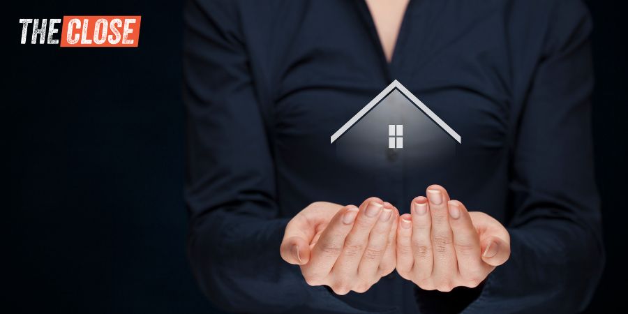 woman dressed in black holding her hands under a small house graphic