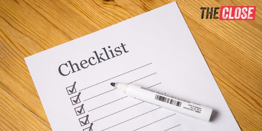 Piece of paper on a wooden table with "Checklist" at the top and lines with checkboxes underneath.