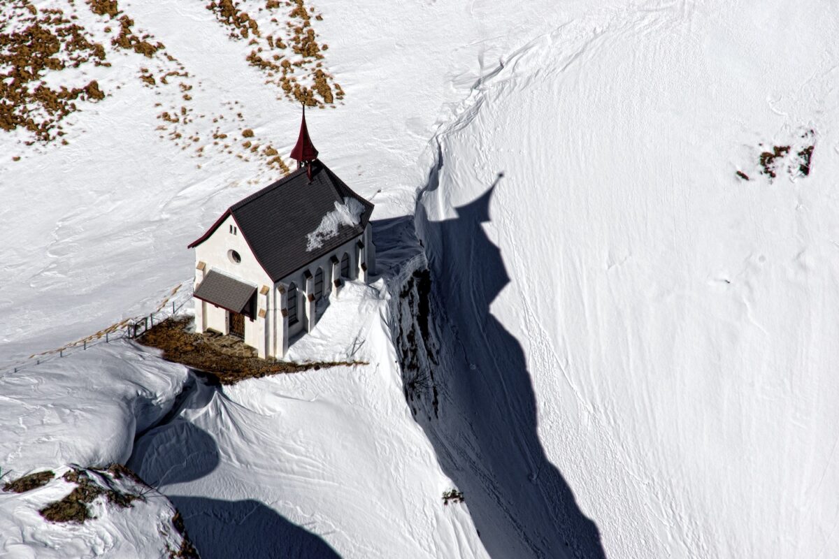 Historic home sits on a cliff covered in snow, representing the risk in this real estate market cycle