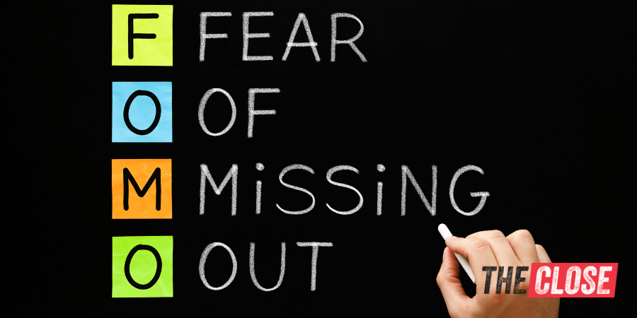 "Fear Of Missing Out" written on a chalkboard with letter FOMO in colors.