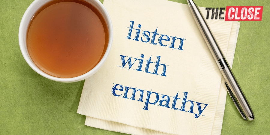 cup of tea, a pen, and a napkin with "listen with empathy" written on it
