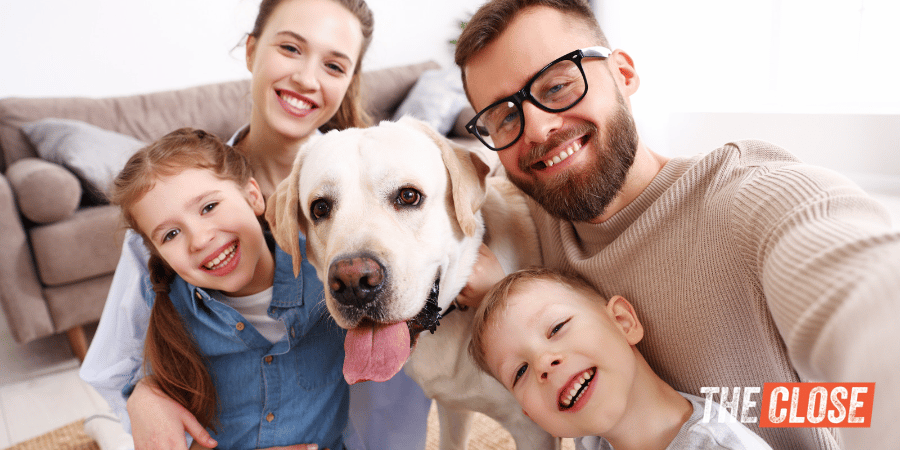 Two parents and two kids pose to take selfie with pet dog