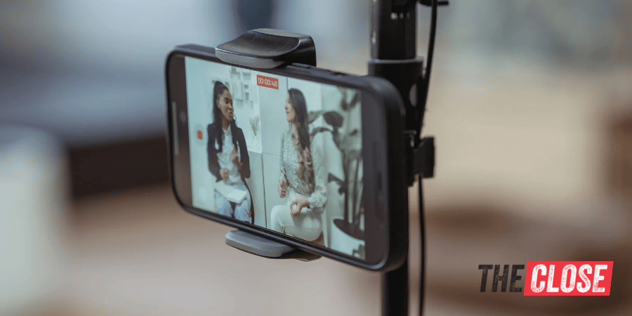 Stand with a smart phone taking a video of two women
