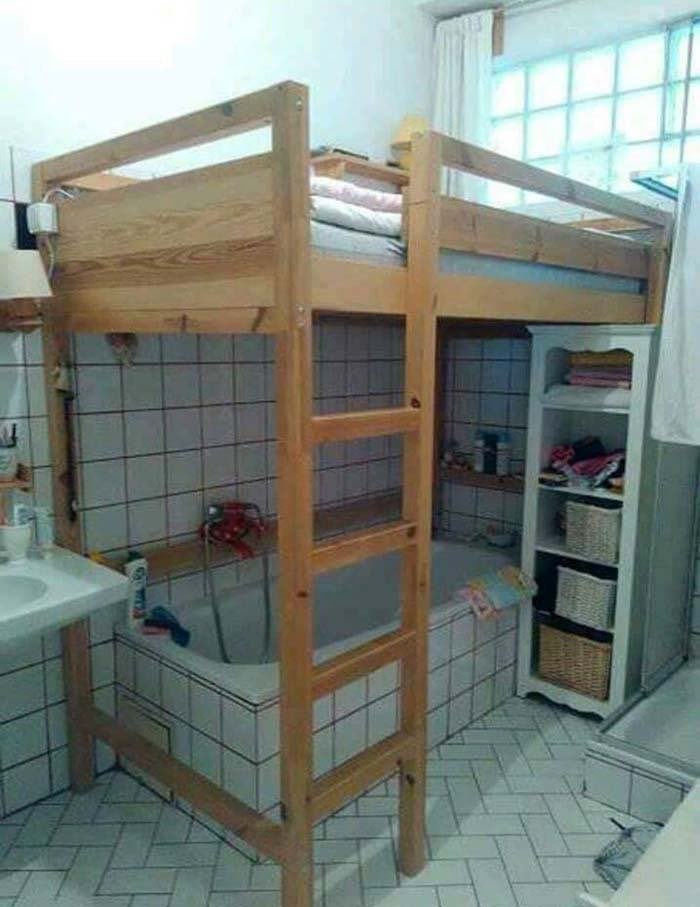 a bathroom with a bunk bed over the tub