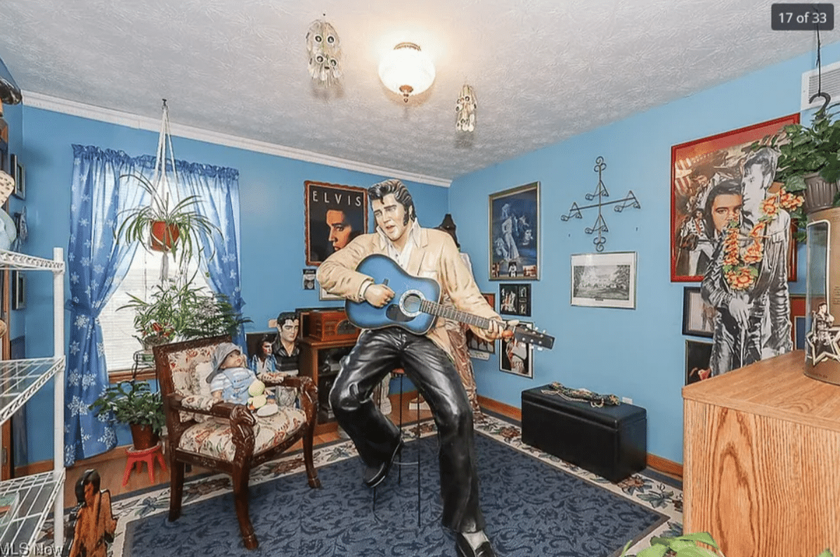 a living room with a strangely positioned life sized elvis statue playing the guitar