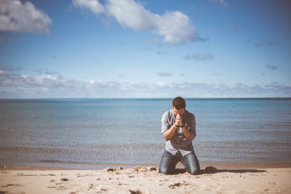 Man praying on a beach