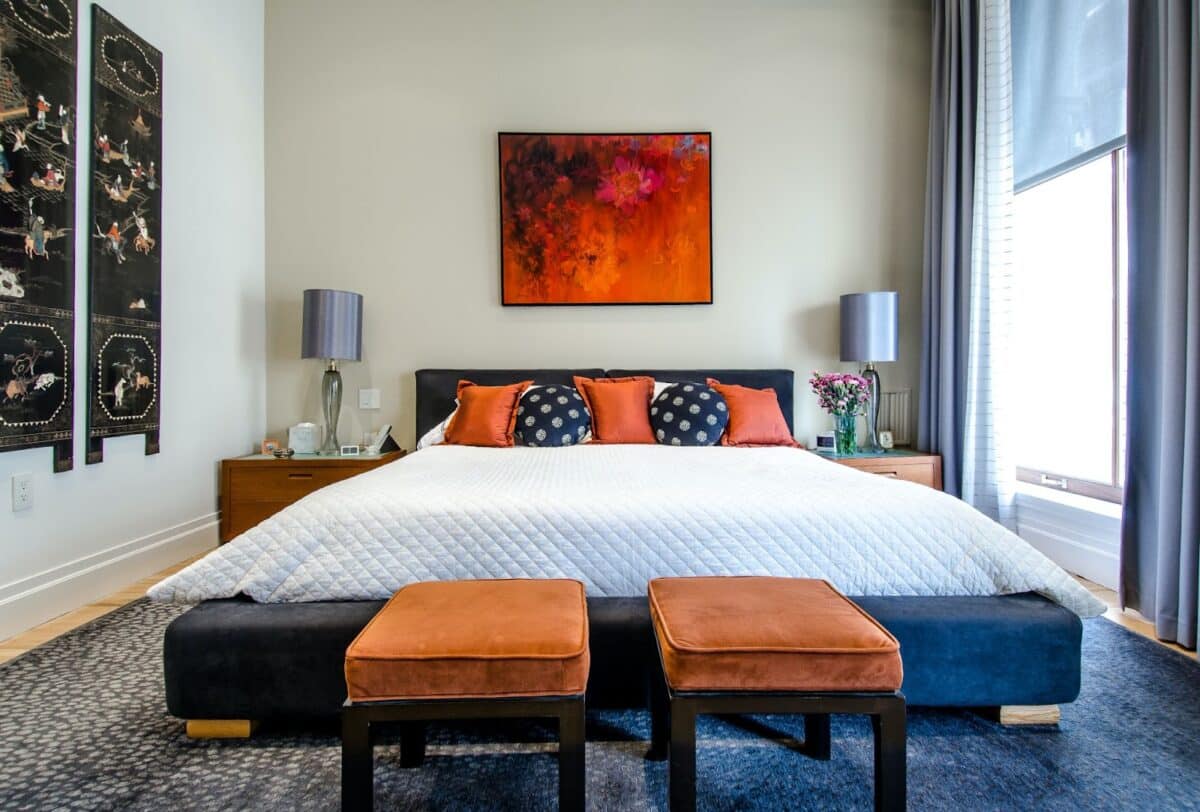 Impact of home staging on a bedroom with blues and red colors and red art on the wall