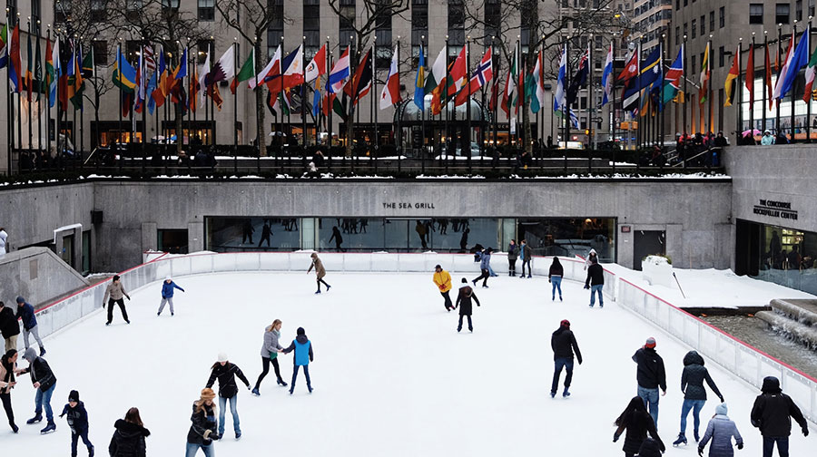 People at Rockefeller Plaza ice skating rink, enjoying the holiday season.