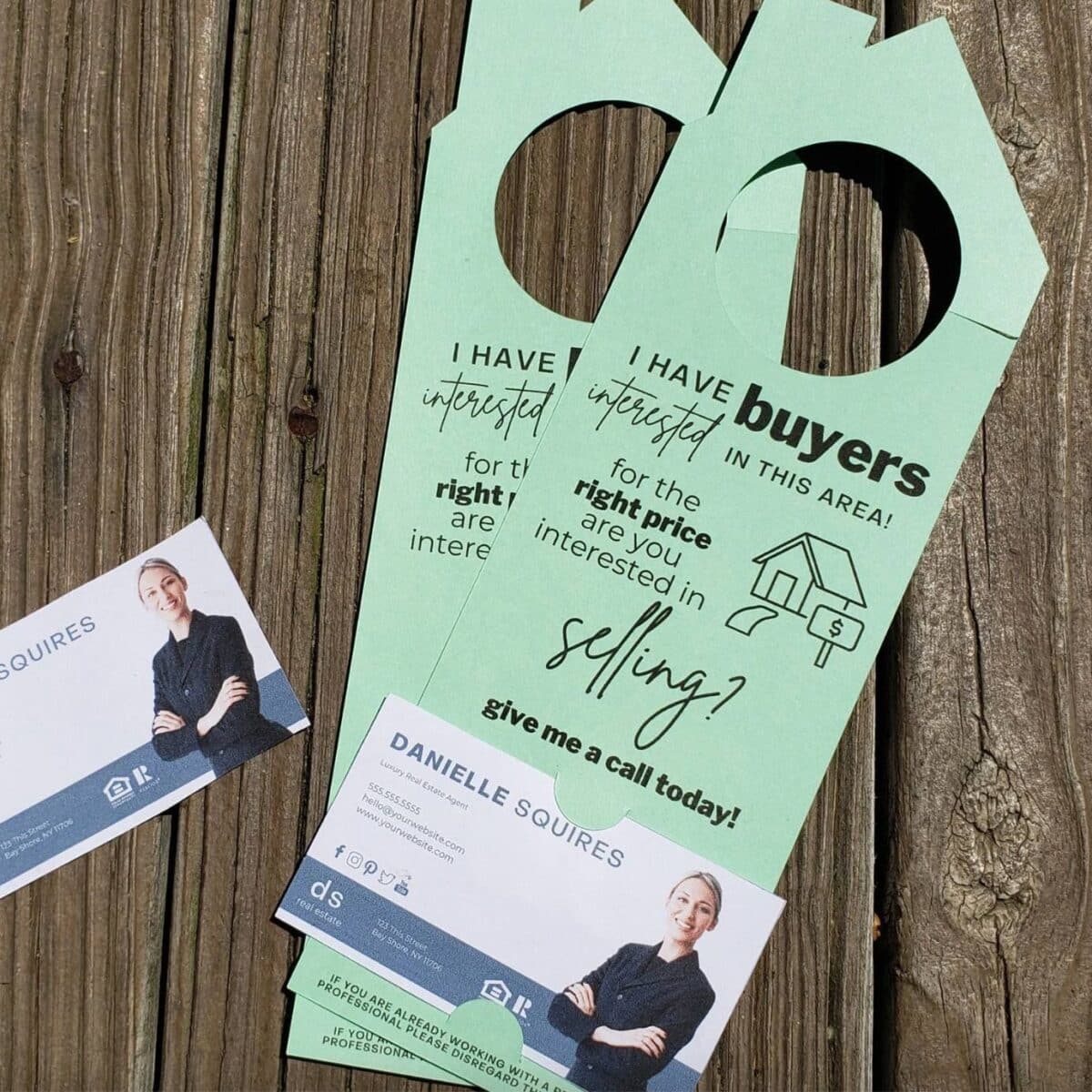 Green door hangers with "I have buyers interested in this area" printed on the front with a slot for a business card at the bottom.