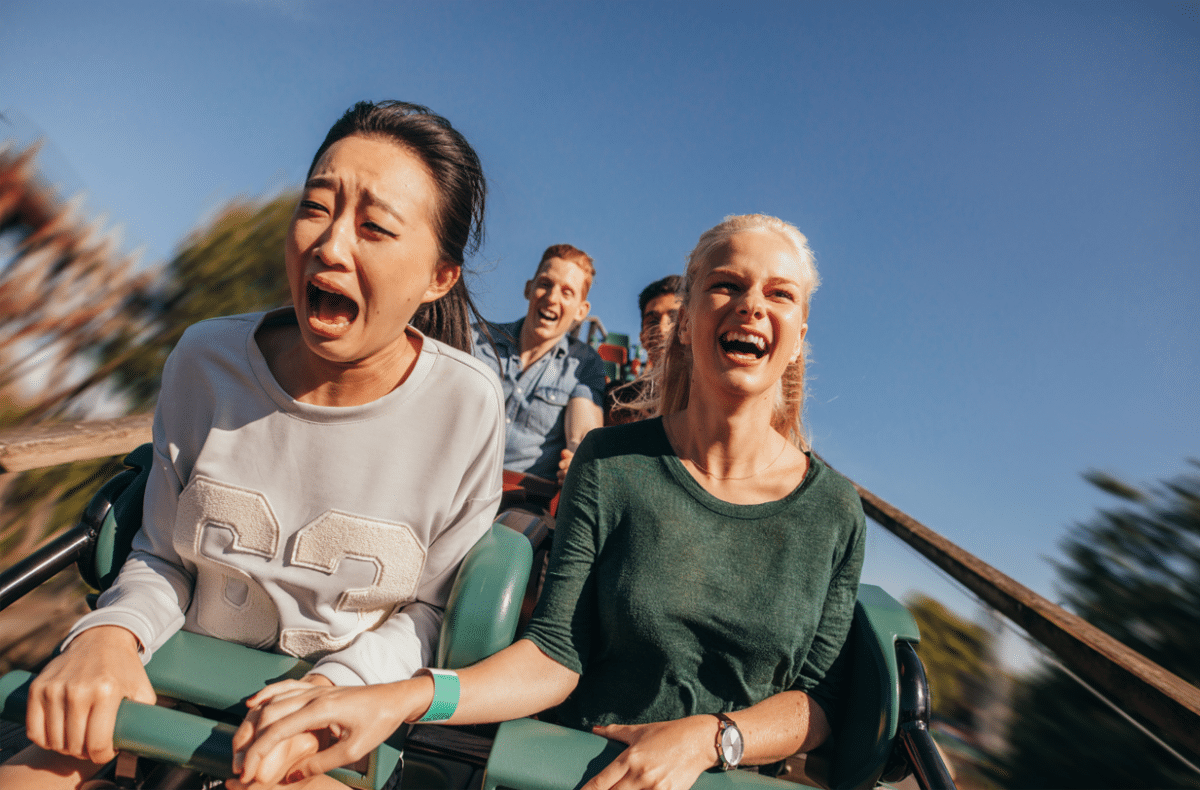 Close up of two women on a fast-moving roller coaster