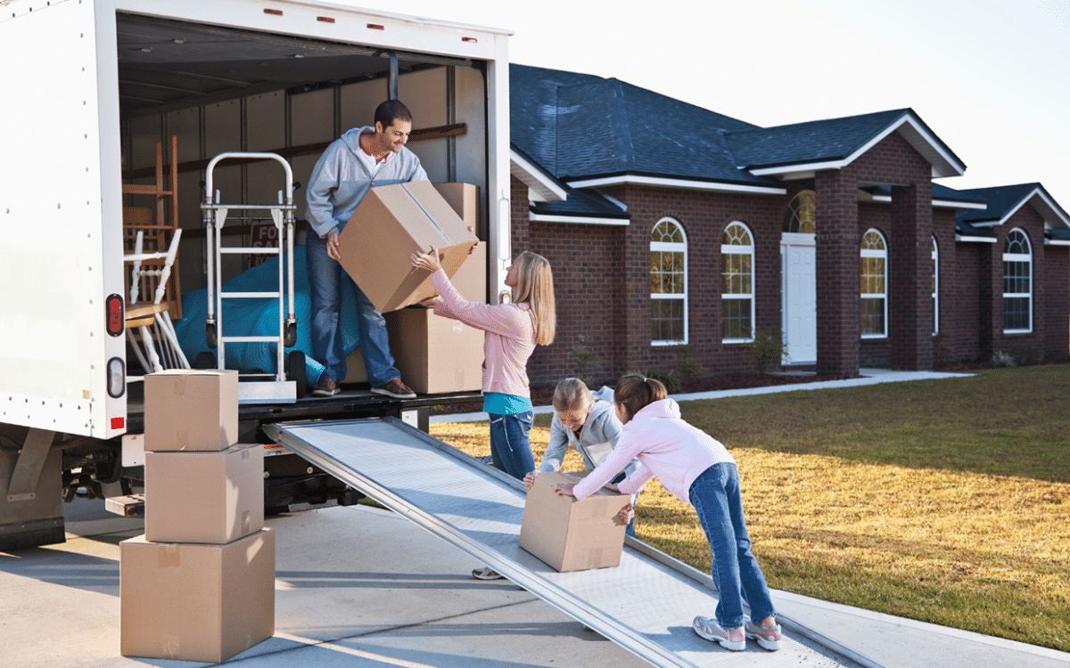 Man, woman, and two young girls loading boxes into a moving truck