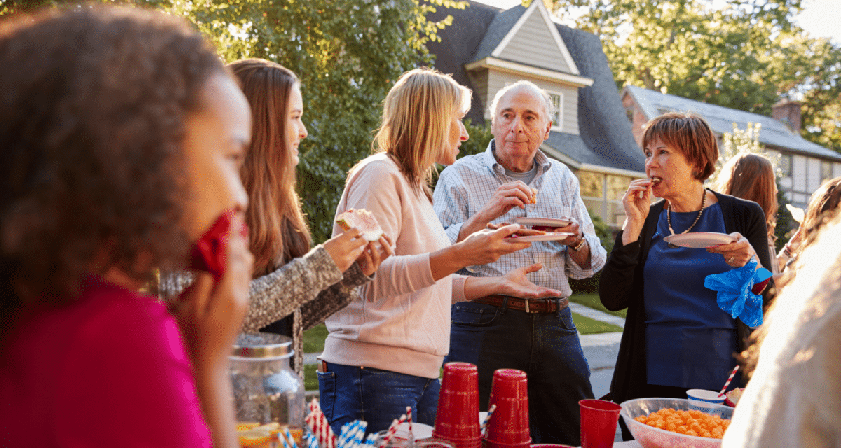 Image of an outdoor block party with people of different ages enjoying conversation.