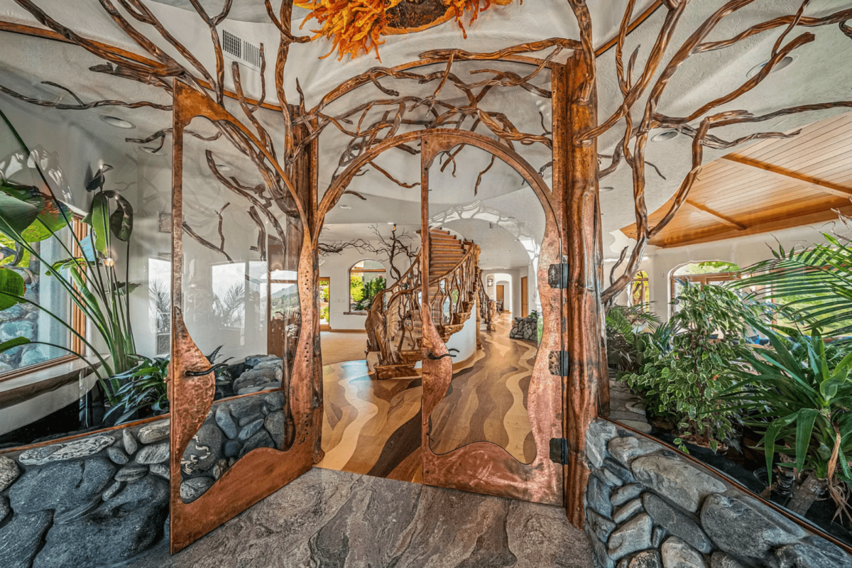 A home's interior decorated with tree-like branches and a signature staircase made of tree trunks