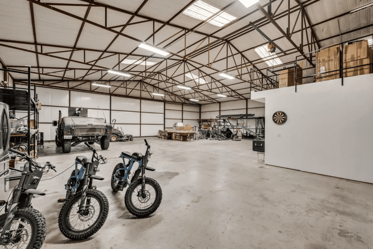 A massive garage with parked bikes and a space that can fit an aircraft