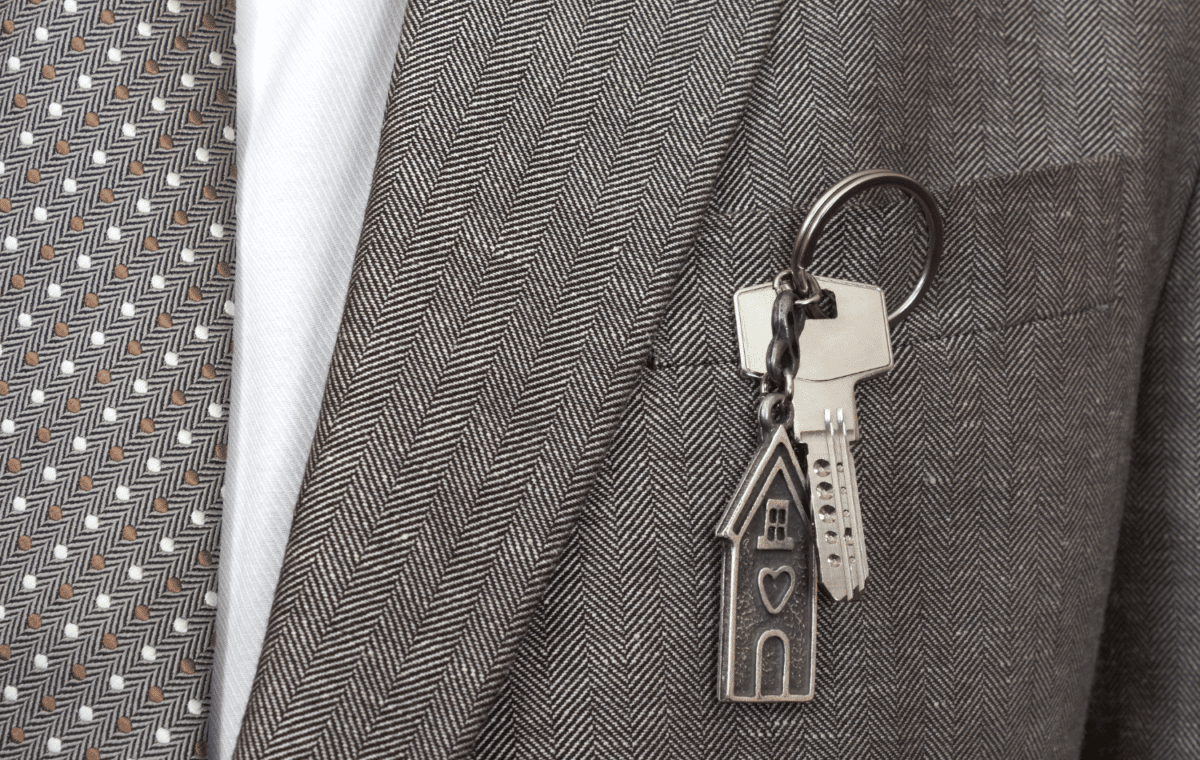 Image of a coat pocket with a house key hanging out of it.